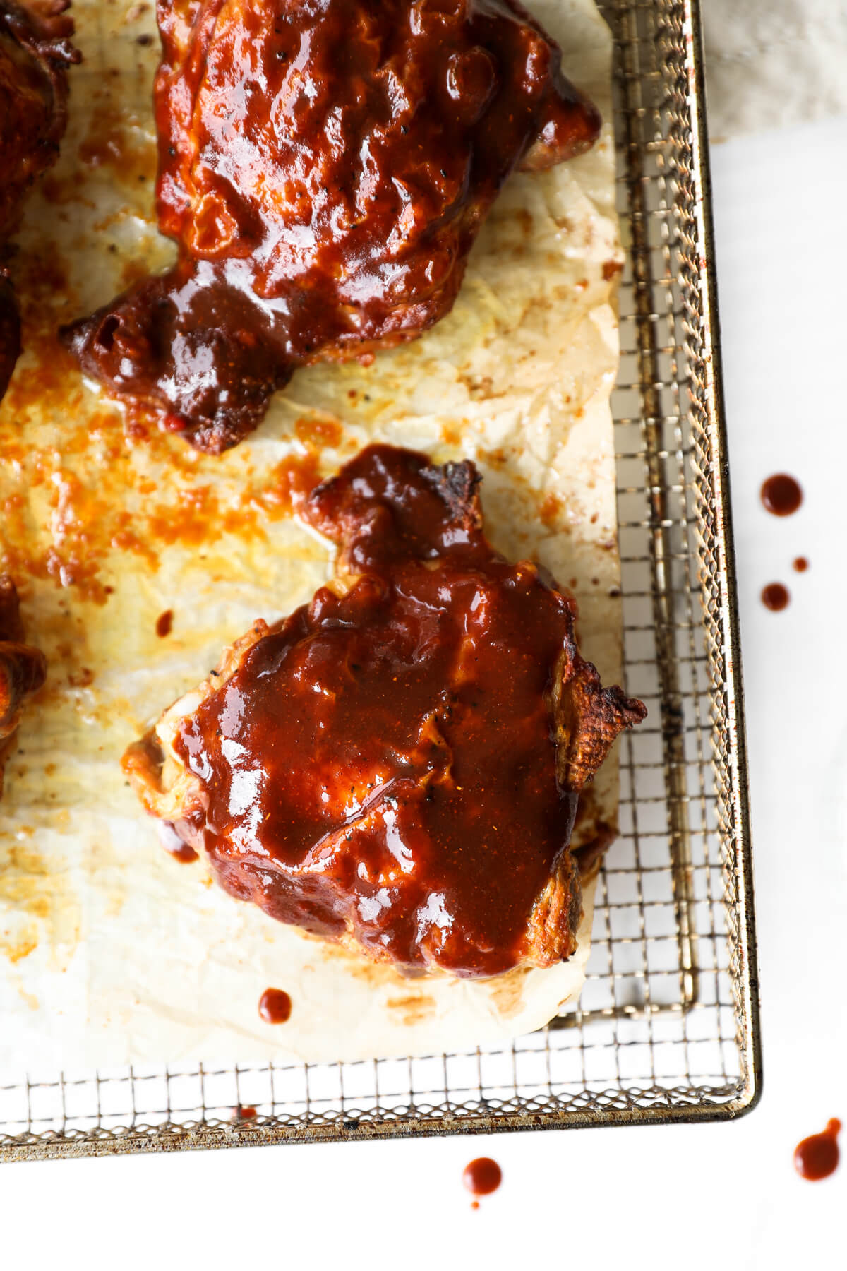 Close up overhead shot of a single cooked chicken thigh with bbq sauce