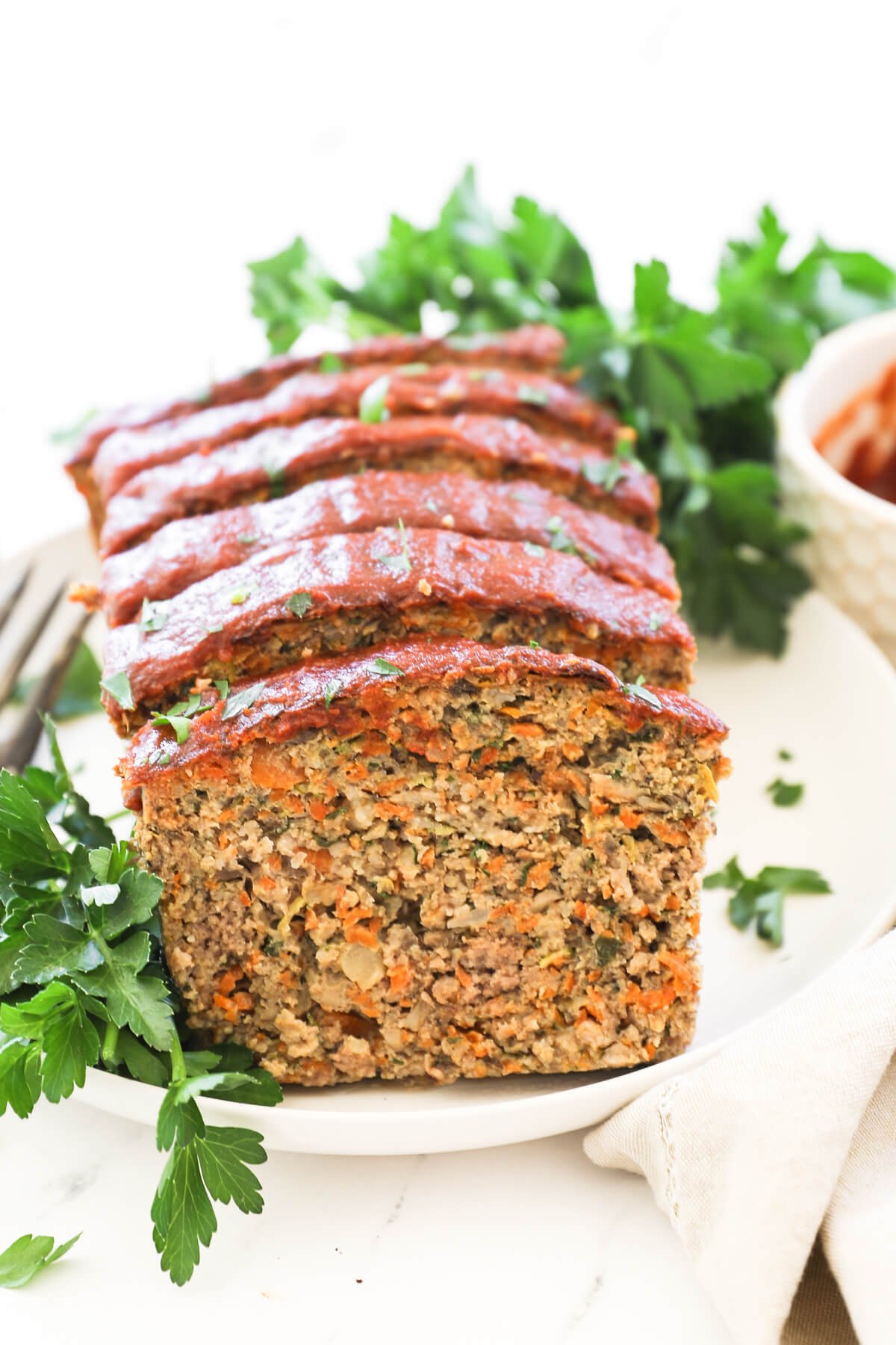 Meatloaf sliced and sitting on a plate so you can see the first slice standing up.