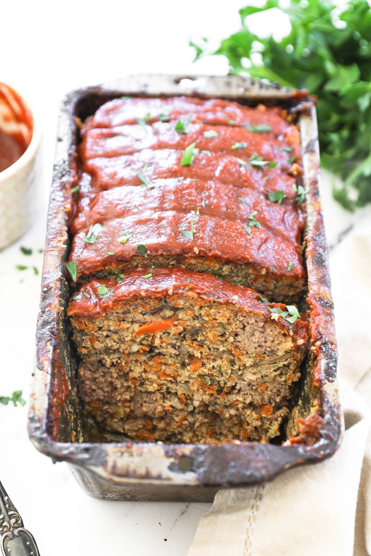 Image of looking at meatloaf sliced in a pan, so you can see the full first slice. 