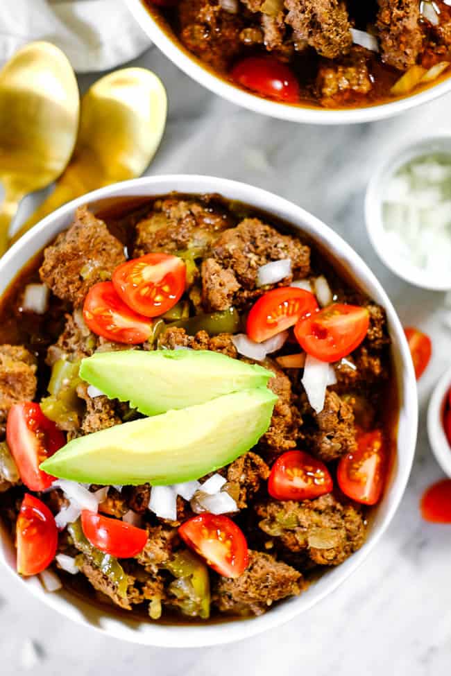 Keto chili served in bowls and topped with chopped onion, tomato and avocado. 