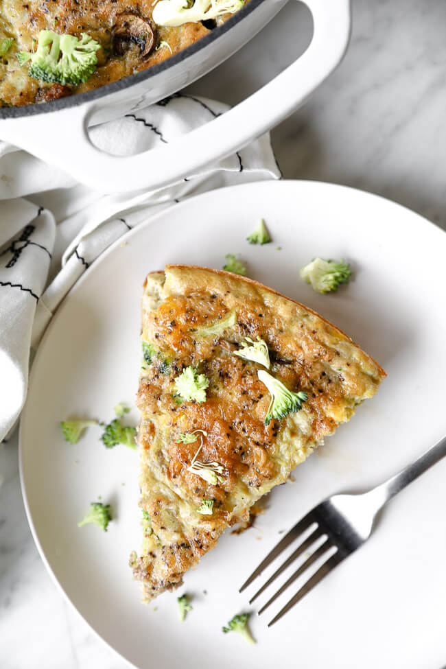 Vertical overhead image of one slice of Keto frittata served on a plate with a fork. 