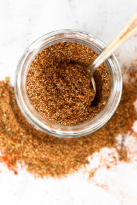 Overhead shot of keto taco seasoning in a jar with spoon coming out