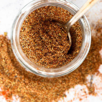 Overhead shot of keto taco seasoning in a jar with spoon coming out