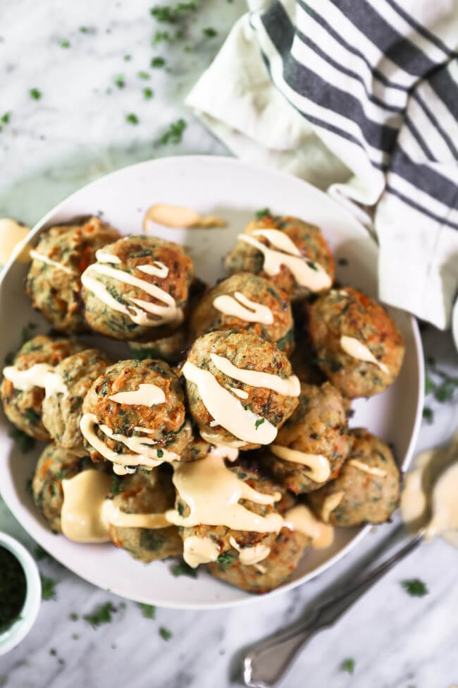 Vertikalt overheadbillede af kalkunfrikadeller på tallerken med sauce drysset på toppen. 