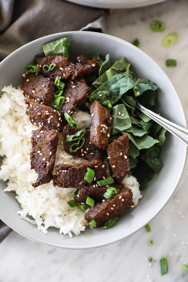 Korean beef bulgogi in a bowl with kale and rice close up vertical image