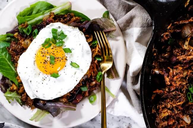 Leftover pulled pork hash horizontal on plate with egg on top