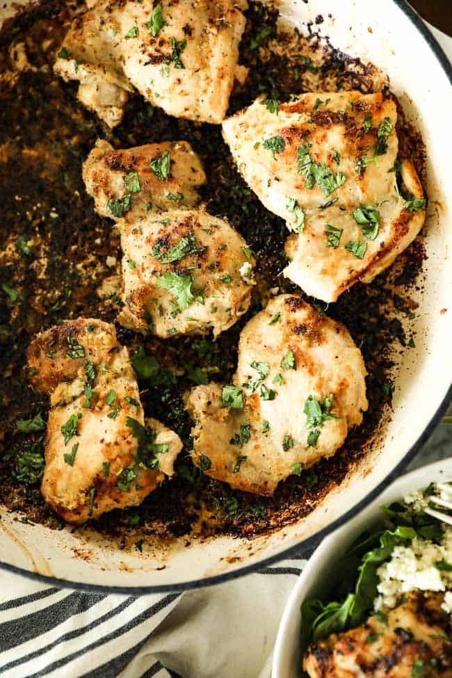Image of lemongrass chicken thighs in a skillet with chopped cilantro sprinkled on top. 