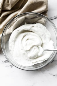 Dairy Free, Vegan whipped coconut cream in a bowl with a serving spoon.