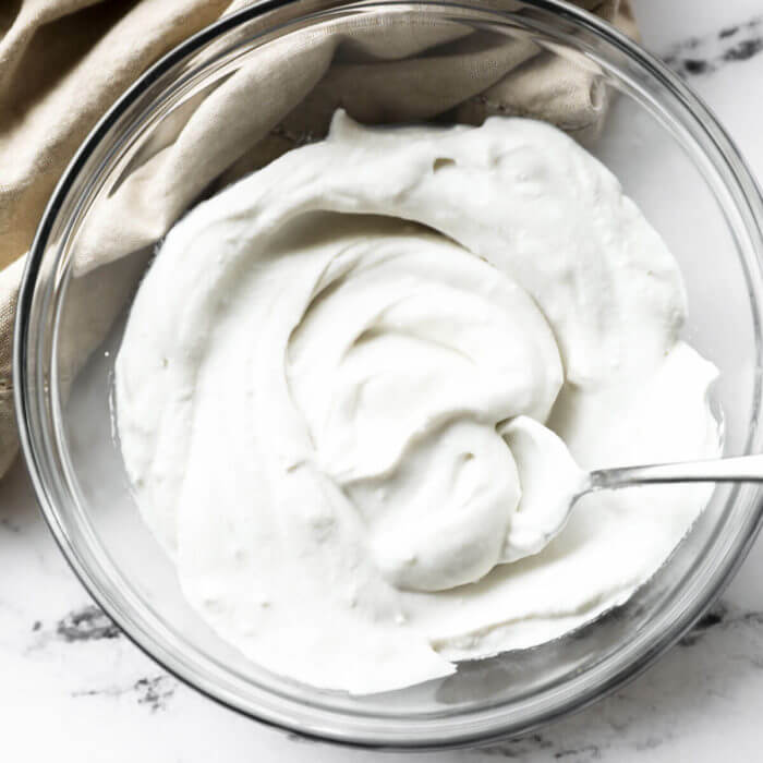 Dairy Free, Vegan whipped coconut cream in a bowl with a serving spoon.