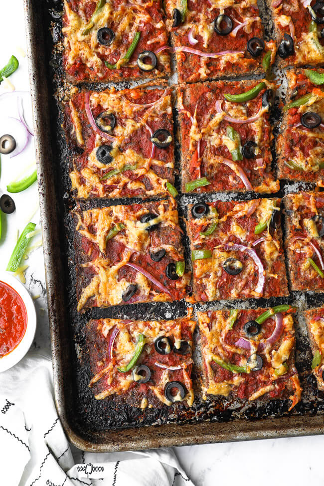 Meatza (or meatzza) pizza on a sheet pan cut into squares (overhead image)