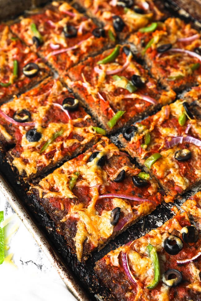 Angled image of sliced low carb meatza on a sheet pan. 