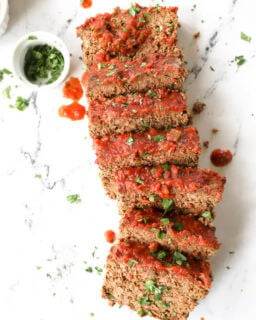 Mexican taco meatloaf sliced and laid out with cilantro and salsa topping.