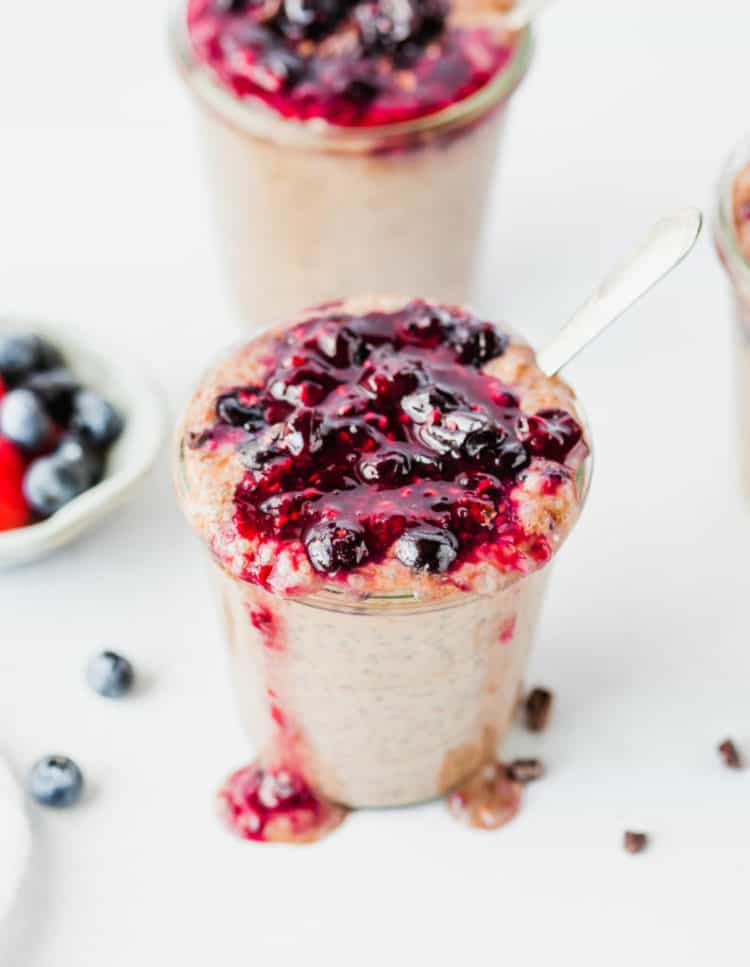 Chocolate berry seed pudding in jar with berries and jam on top