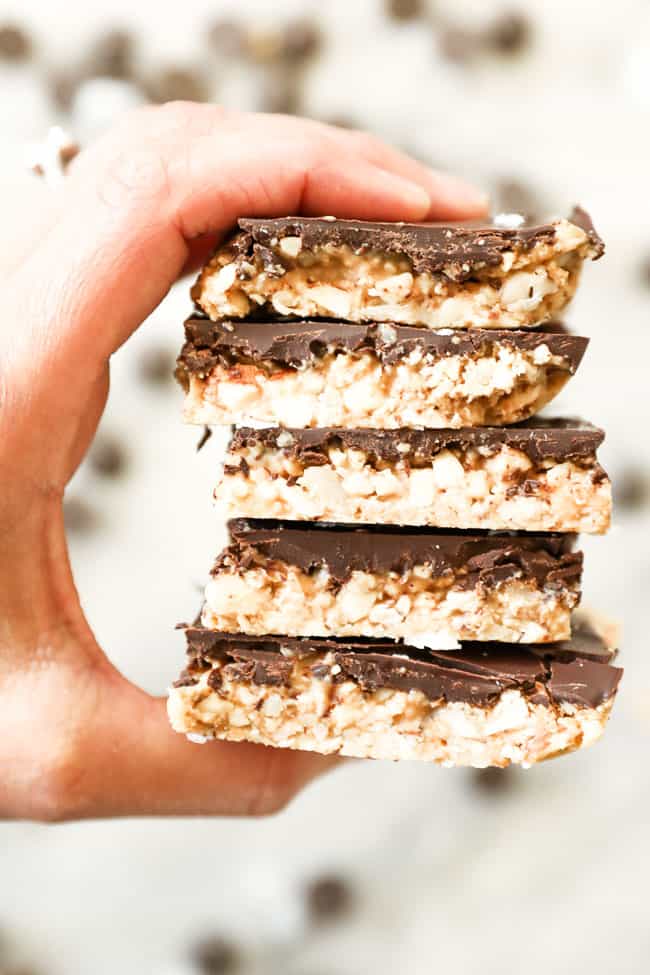 Holding a stack of peanut butter bars. 