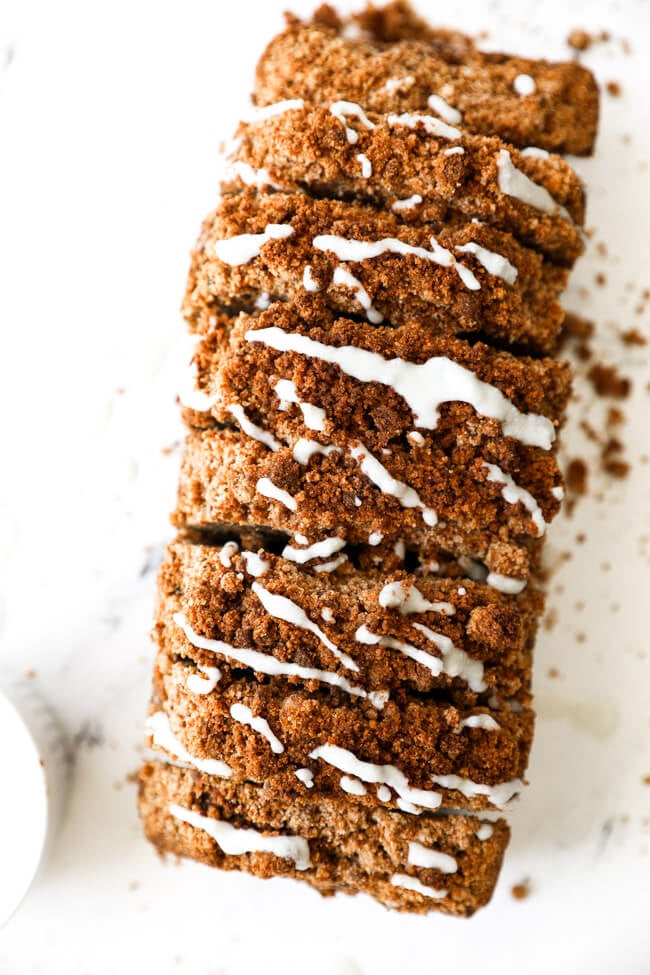 Overhead image of a loaf of gluten free and dairy free pumpkin bread with coconut butter drizzled on top.