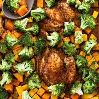 Overhead shot of one pan baked chicken and broccoli with squash pieces and a spoon in the pan