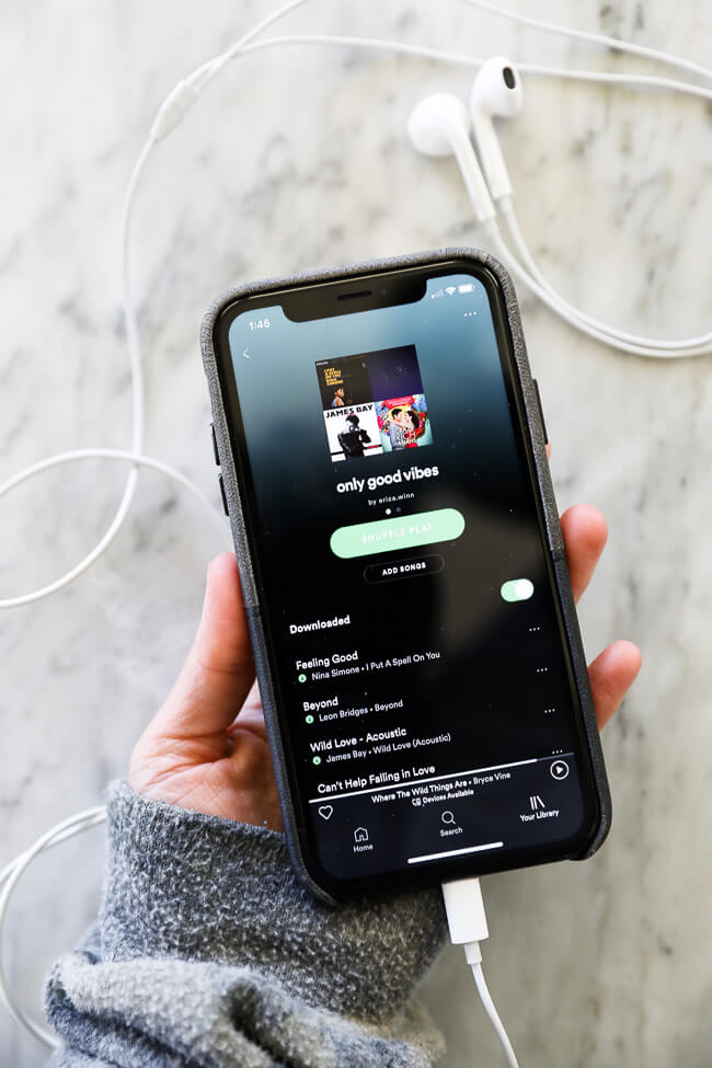 Vertical image of holding iPhone with only good vibes playlist open on it. 