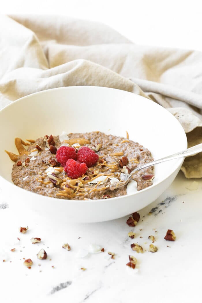 Angled image of chia pudding in a bowl with a spoon in it.