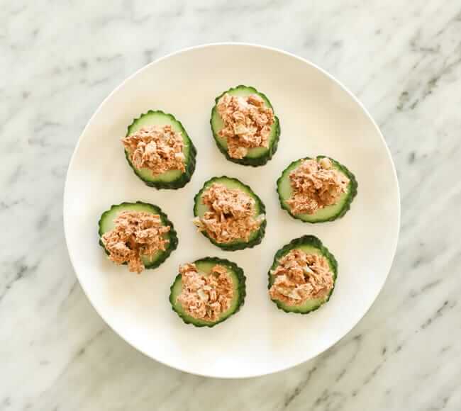 cucumber slices topped with tuna on a plate