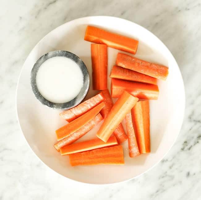Sliced carrots with coconut butter on a plate