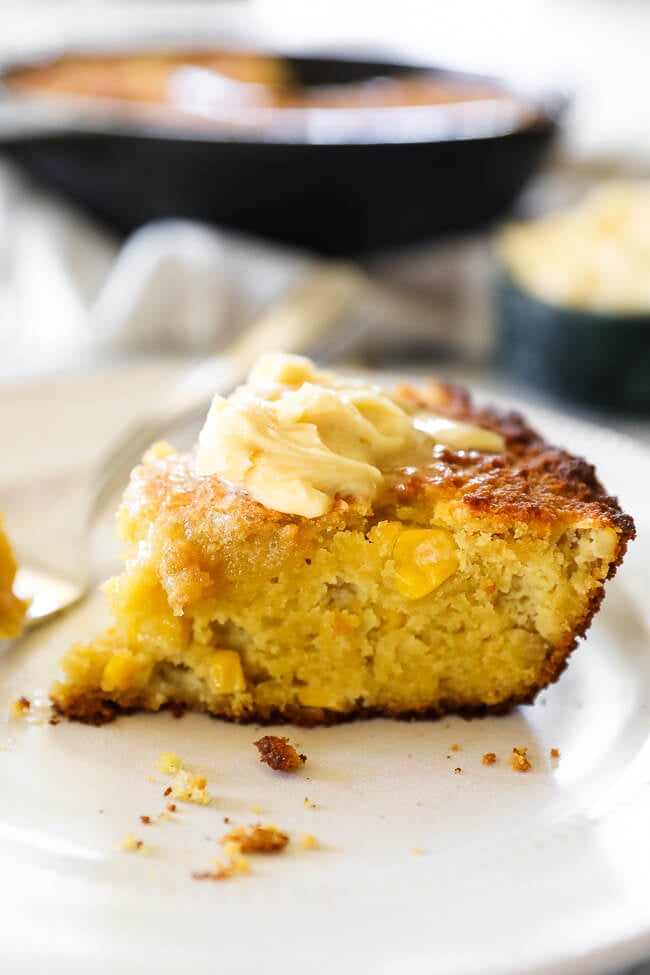 Angled image of a slice of paleo cornbread with whipped honey butter on top. 