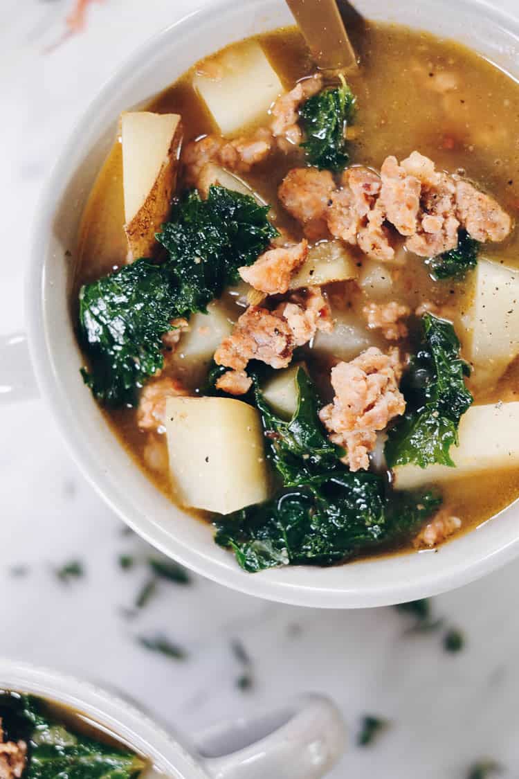 Curling up with a big bowl of this Paleo sausage soup feels so comforting and soul-satisfying. It's filled with roasted garlic, potatoes and kale. Paleo, Whole30 and Dairy-Free. | realsimplegood.com
