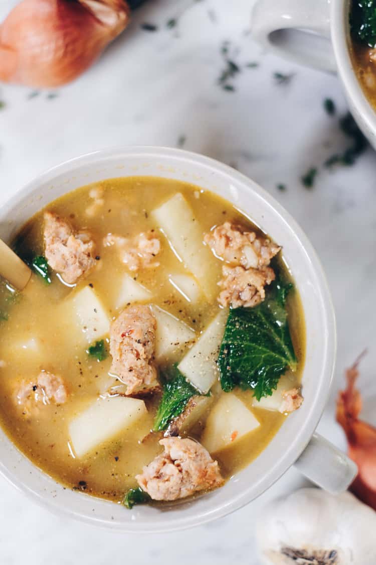 Curling up with a big bowl of this Paleo sausage soup feels so comforting and soul-satisfying. It's filled with roasted garlic, potatoes and kale. Paleo, Whole30 and Dairy-Free. | realsimplegood.com