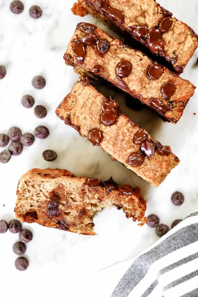 Paleo chocolate chip banana bread slices. One slice with a bite taken out of it and extra chocolate chips scattered about. 