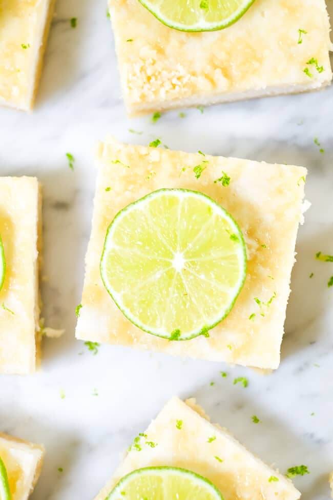 Paleo lime bars topped with lime zest and sliced lime. 
