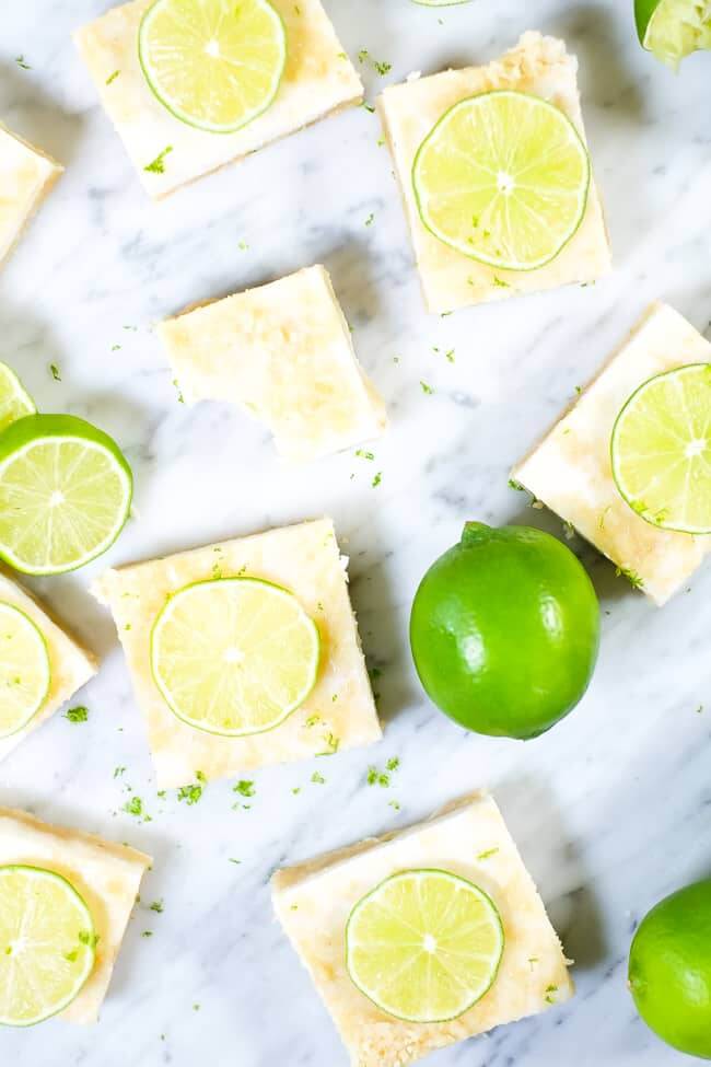 Paleo lime bars topped with lime zest and sliced lime. 