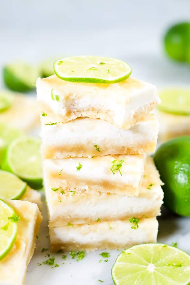 Stack of Paleo lime bars topped with lime zest and sliced lime. 