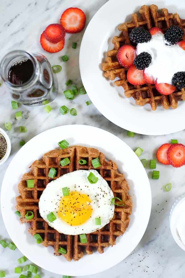 Sweet and savory Paleo waffles. One topped with berries and coconut whipped cream and the other with a fried egg and green onion. 