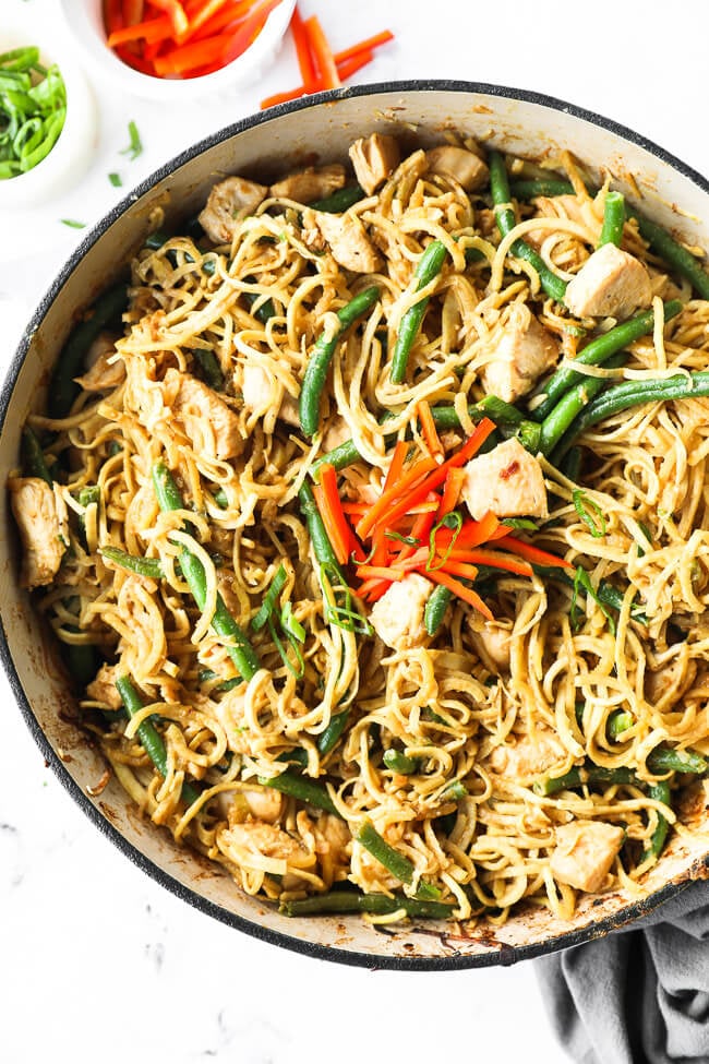 Large skillet filled with peanut butter chicken and spiralized sweet potato noodles. 