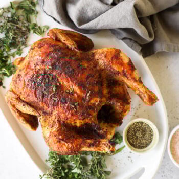 Overhead image of a whole roasted chicken on a platter after cooked in the air fryer.
