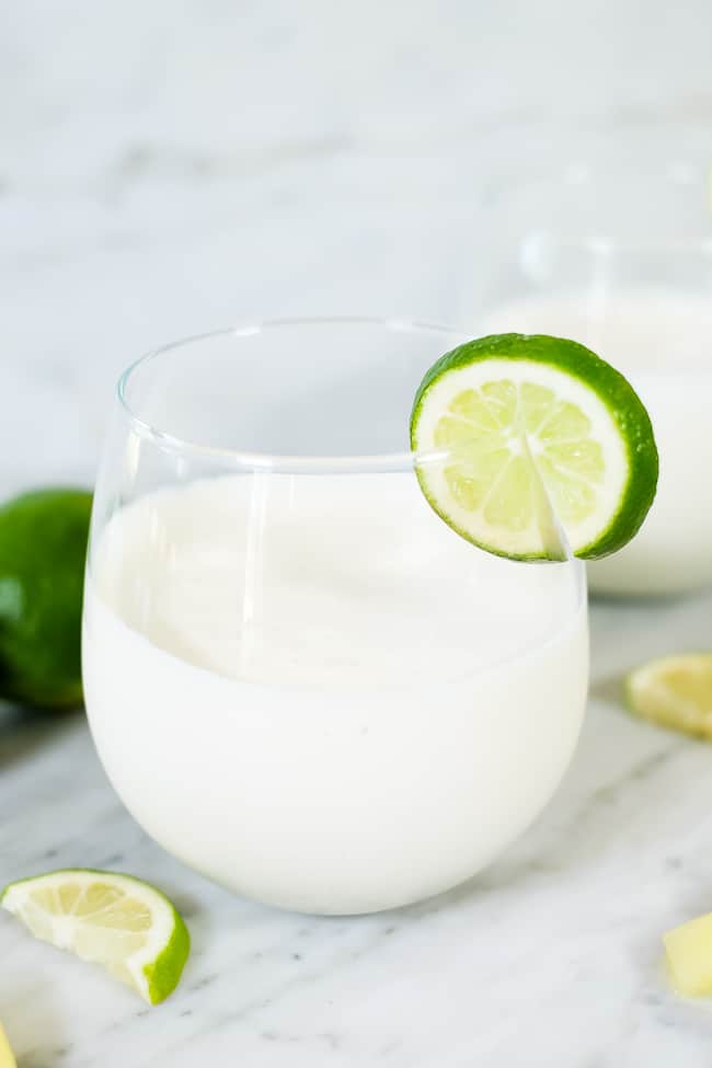 A paleo, dairy-free and refined sugar-free piña colada smoothie garnished with a slice of lime. 