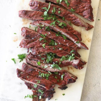 Quick and easy carne asada on a board cut into strips topped with salt and cilantro