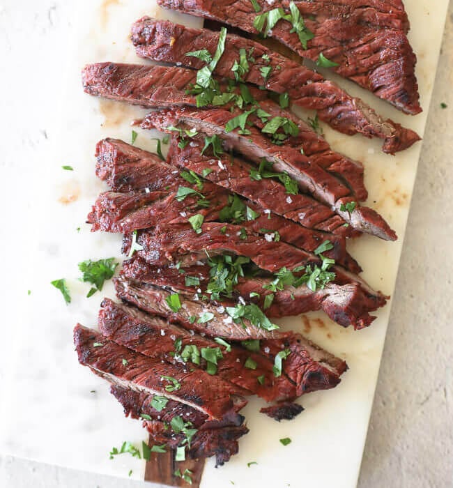 Quick and easy carne asada on a board cut into strips topped with salt and cilantro