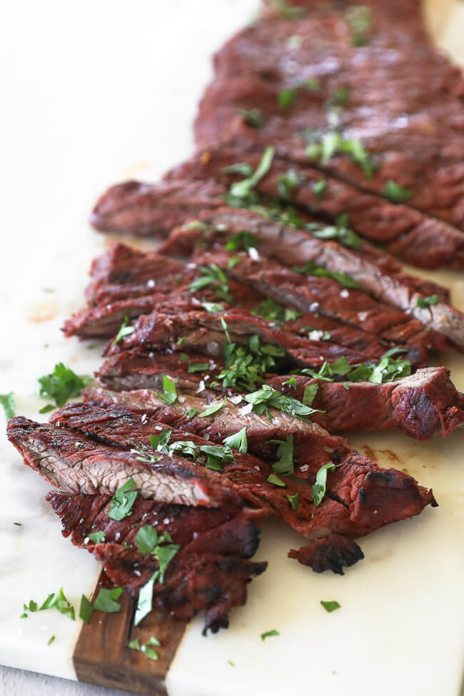 Quick and easy carne asada on a board cut into strips topped with cilantro close up angle shot