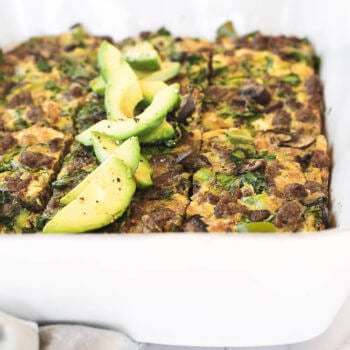 Keto breakfast casserole sliced in a dish with sliced avocado close up angle image