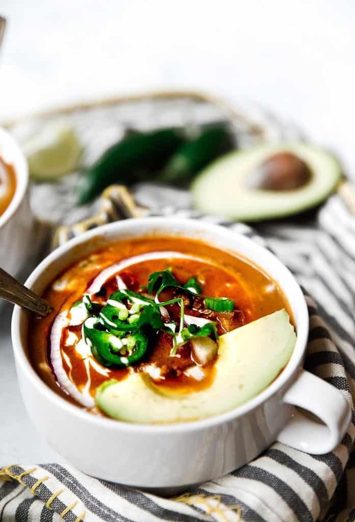 Taco soup in a bowl with onion, jalapeno and avocado