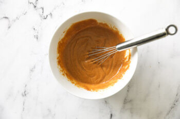 Peanut sauce in a ramekin with whisk poking out