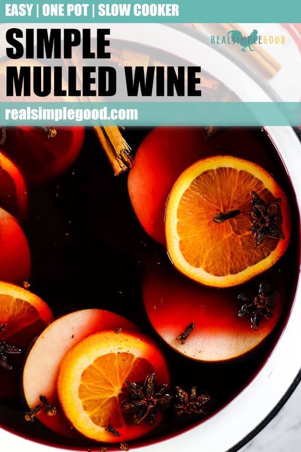 Simple mulled wine recipe in large dutch oven with slices of orange, apple, cloves, star anise and cinnamon sticks. Long pin for pinterest. 