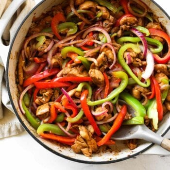 Overhead image of chicken fajita tacos fillings in a skillet with spoon