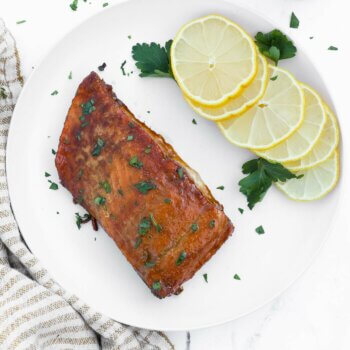 Overhead shot of smoked salmon with lemon wedges and chopped parsley