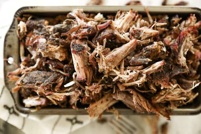 Horizontal image of smoked pork shoulder shredded in a pan 