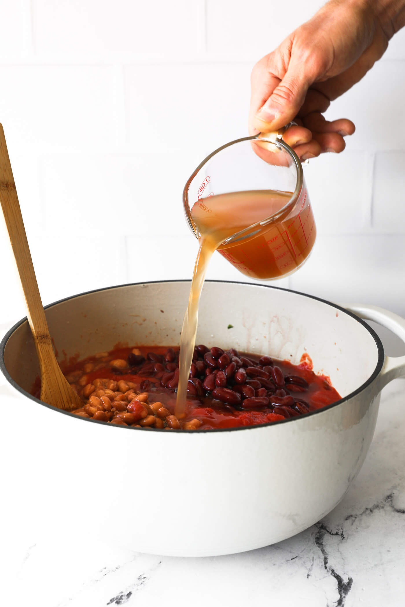 Pouring broth into dutch oven. 