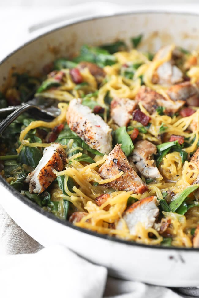 Vertical close up angled image of spaghetti squash carbonara in skillet. 