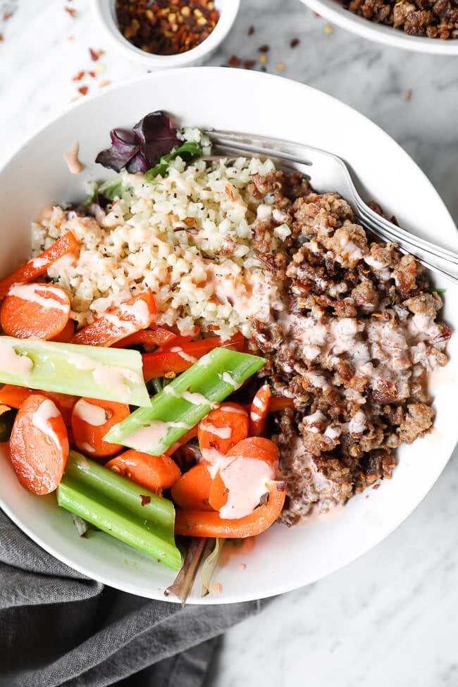 Spicy ground pork bowls with veggies and sauce over the top