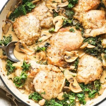 Overhead shot of creamy mushroom chicken in a pan with creamy dairy free sauce and kale