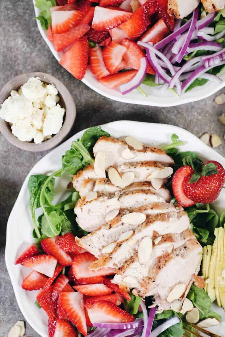 In just 30 minutes this Paleo + Whole30 savory and sweet strawberry chicken salad will be on the table! It's full of flavor and super easy to make! Simple chicken pairs perfectly with arugula, spinach, strawberries, avocado, red onion, sliced almonds and an easy balsamic dressing. Paleo + Whole30 | realsimplegood.com